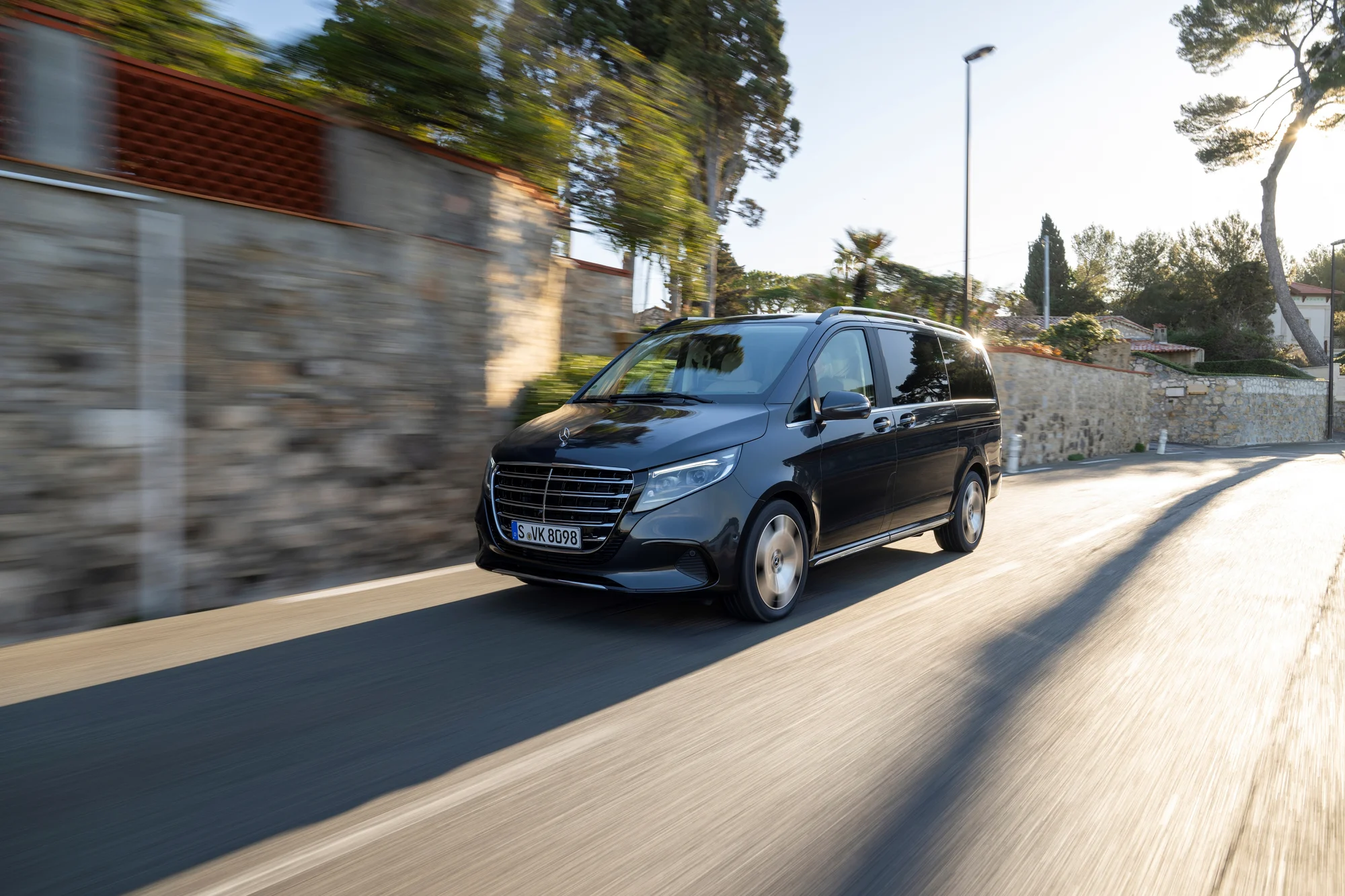 Čierny Mercedes-Benz triedy V počas jazdy na pokojnej ceste